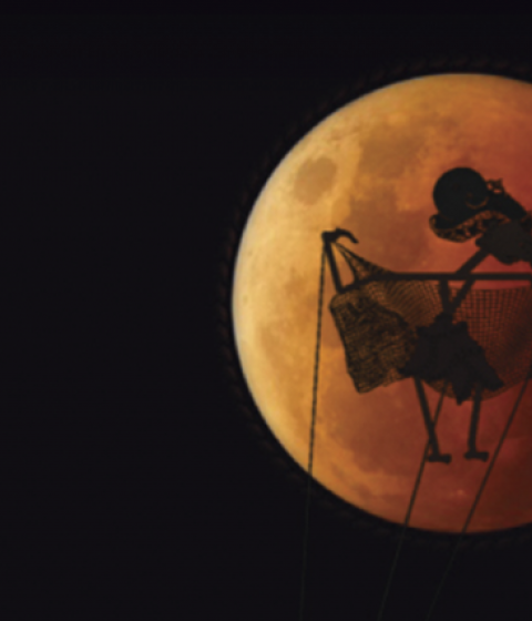 Puppet Silhouetted Against a Red Moon