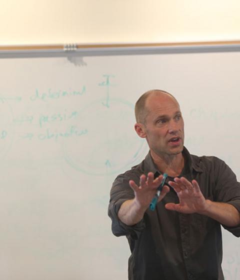 Christoph Cox in classroom in front of whiteboard
