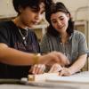 Two students work together in an art studio.