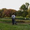 Student walks bike through the farm.