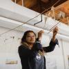 Student holding hanging sculpture.