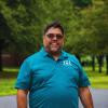 Carlos standing outside wearing a blue shirt.