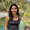 Priyanka Basnet smiles at the camera in a black tank top outside.