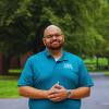 Robert Gordon in a blue shirt standing outside.