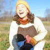 Charlotte Senders laughing in the sun with a chicken,
