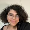 A person in glasses and a black top smiling.