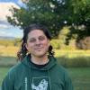 Isaac (Ike) Rubin wearing a green hoodie, smiling outside against a green landscape